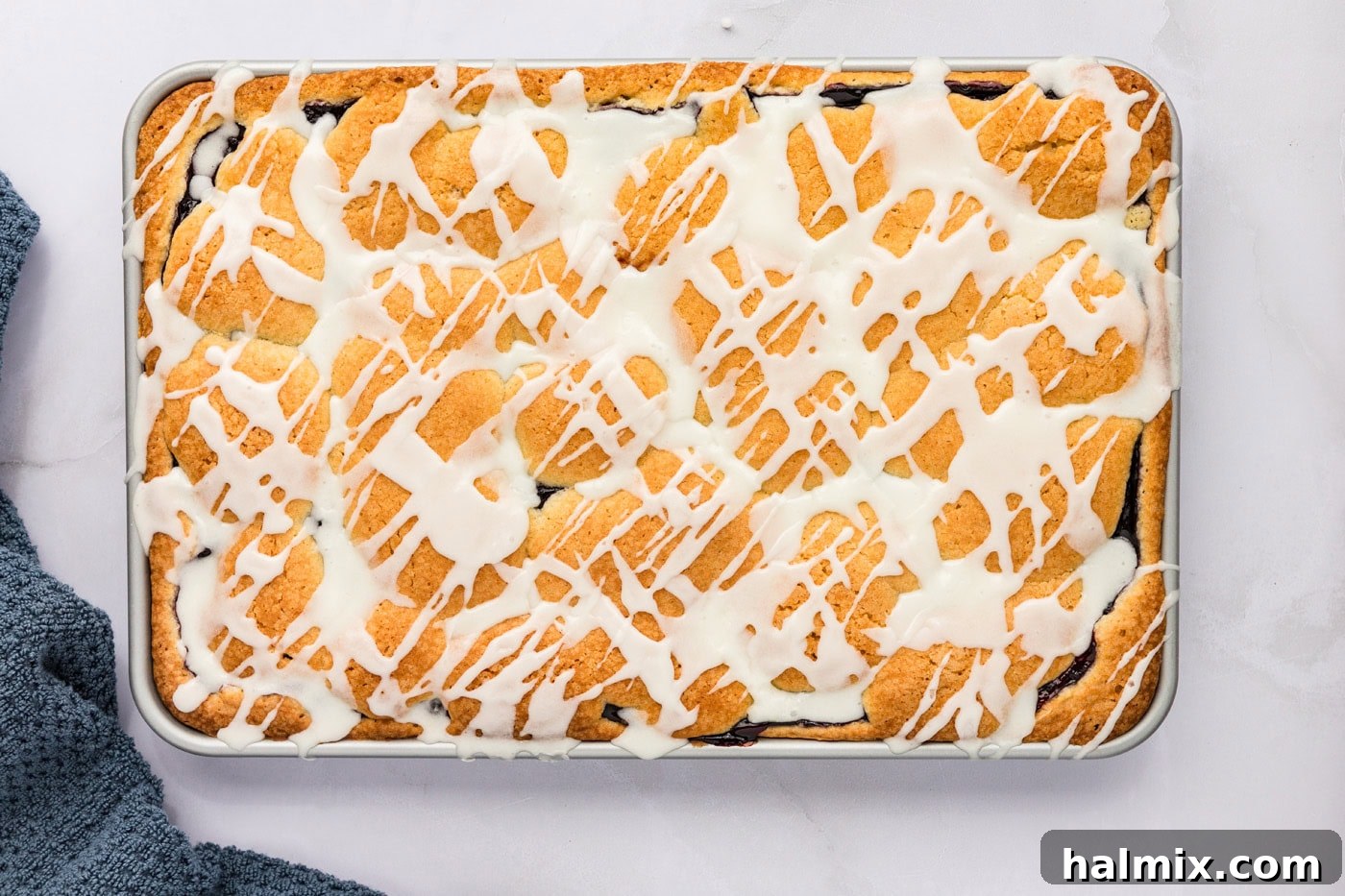 overhead shot of glaze drizzled over blackberry pie squares