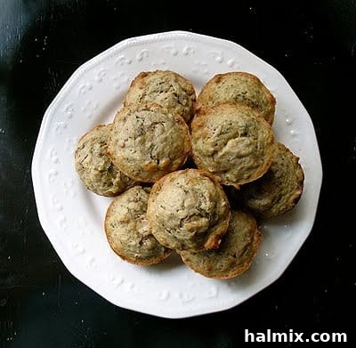 An overhead photo of vanilla zucchini muffins on a white plate, showcasing their golden-brown tops and inviting texture.
