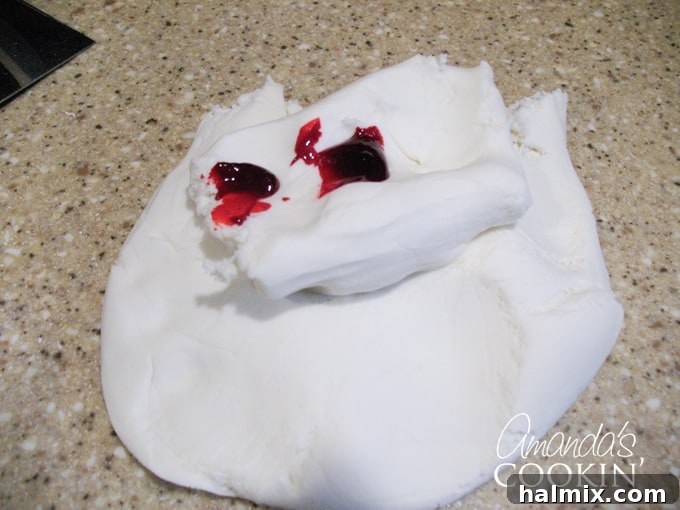 Spiderman Cake Power-Up: Homemade Marshmallow Fondant 4 A photo of white fondant with red food coloring on top.