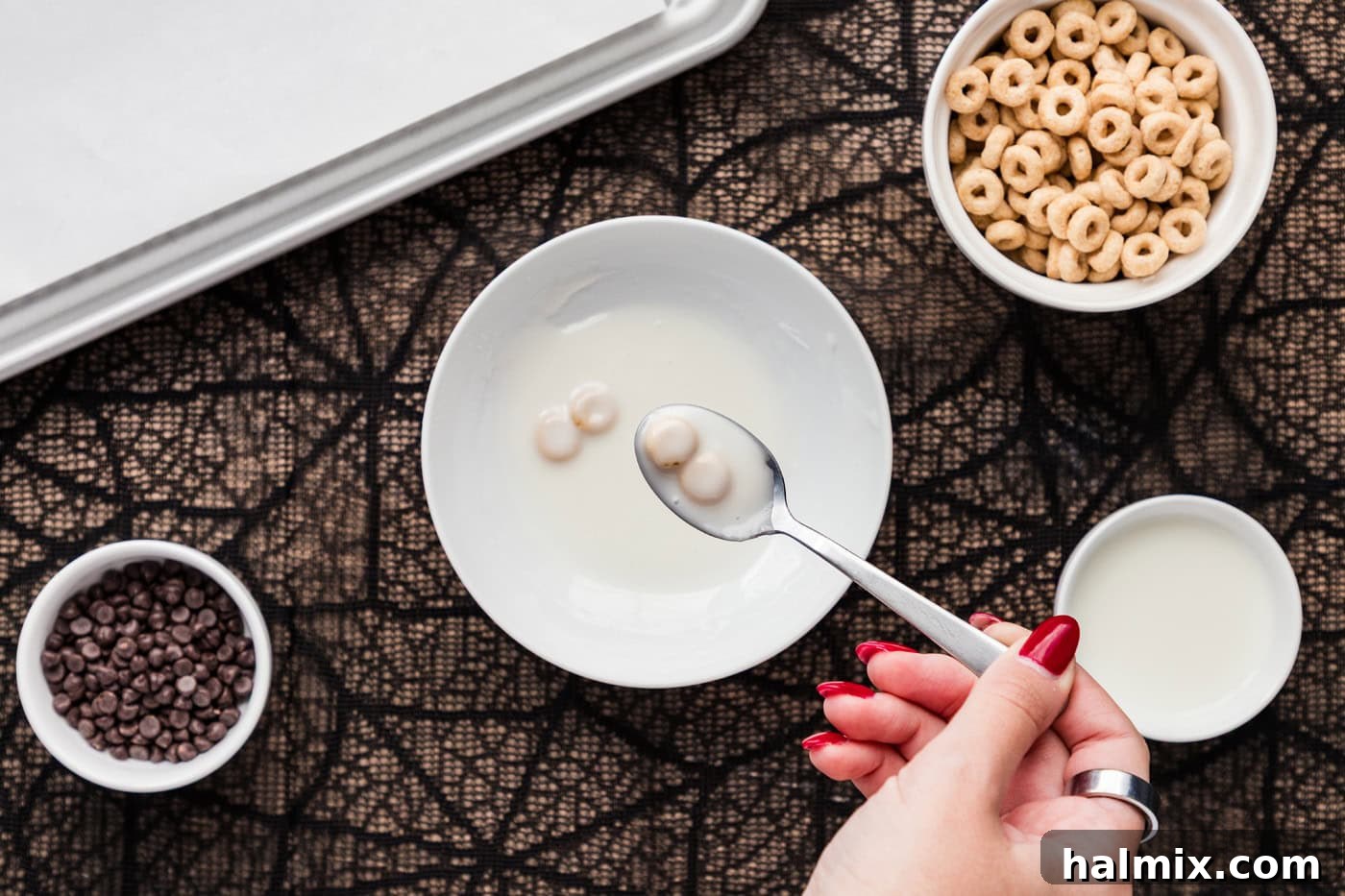 Spooning glazed Cheerios onto a baking sheet
