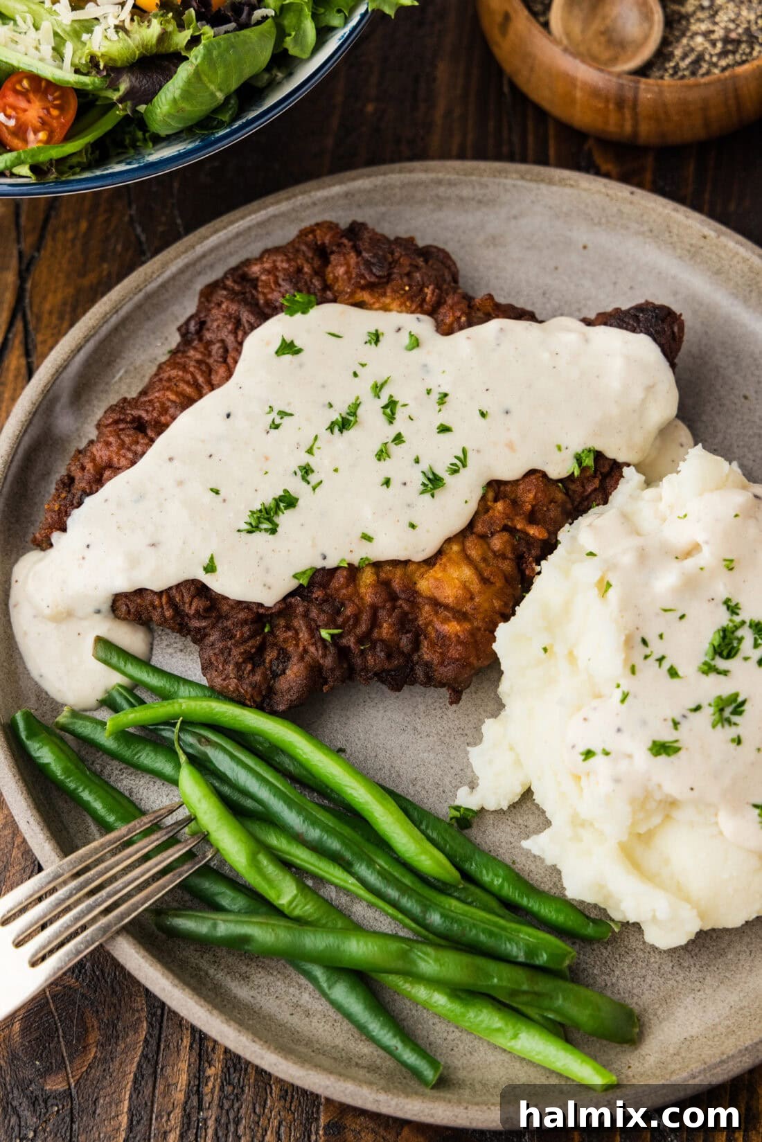 Chicken Fried Steak on a plate with mashed potatoes and green beans