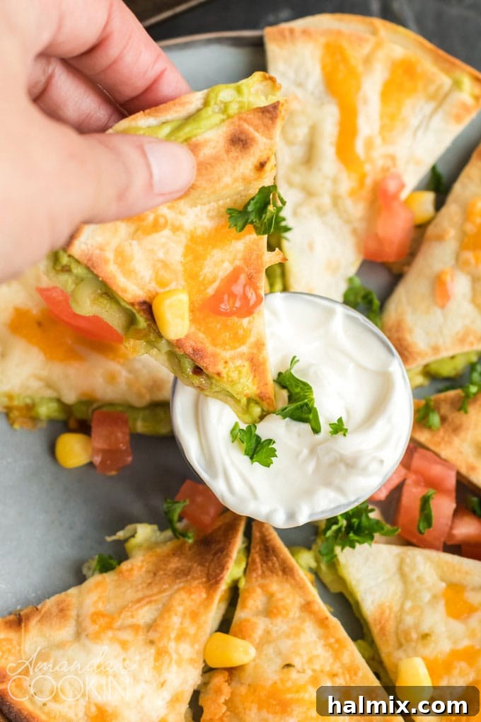 Quesados: Delicious Mexican appetizers with cheese, guacamole, and sour cream, ideal for parties. Crispy Quesados, a Mexican appetizer, perfectly dipped in sour cream on a festive plate.