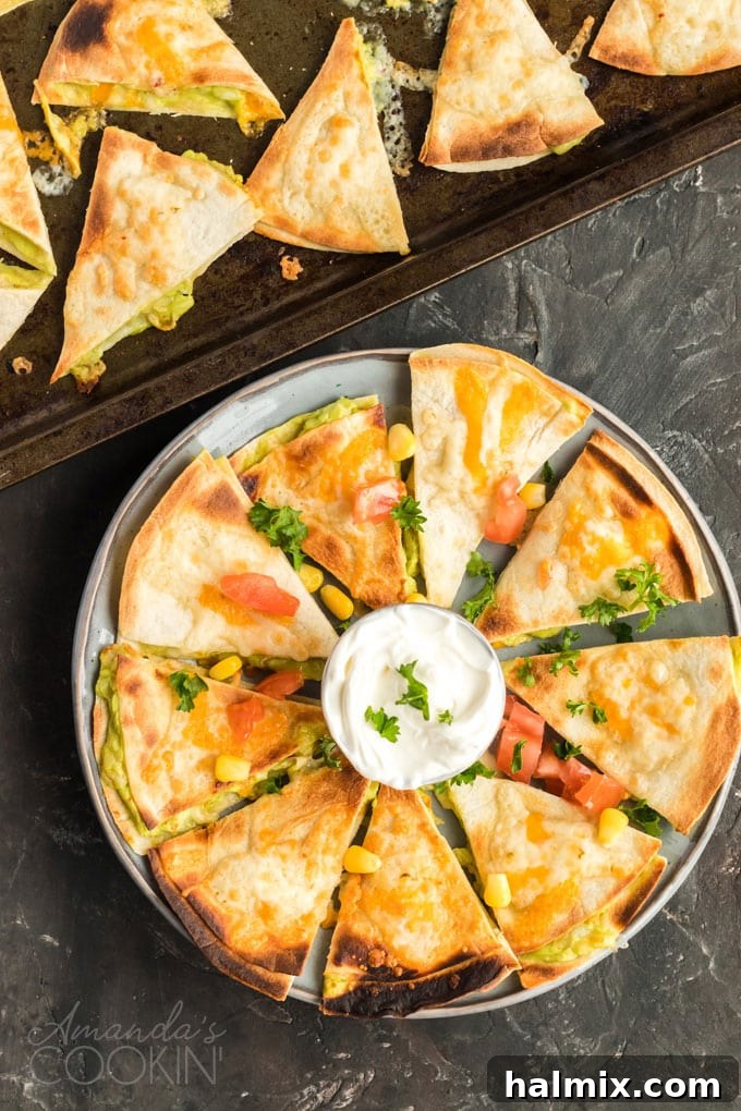 Quesados: Delicious Mexican appetizers with cheese and guacamole filling, perfect for parties. Beautifully arranged sliced quesados, a vibrant Mexican appetizer, presented on a plate for serving.