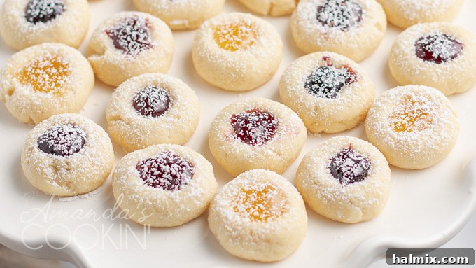 A selection of thumbprint cookies with various jam fillings, arranged artfully, highlighting their vibrant colors and perfect indentations.