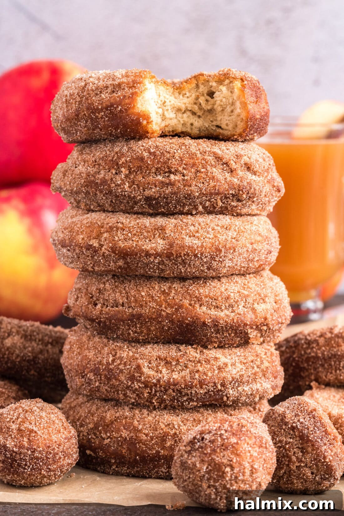 Stack of Apple Cider Doughnuts with a bite taken out of the top one, showcasing their soft texture