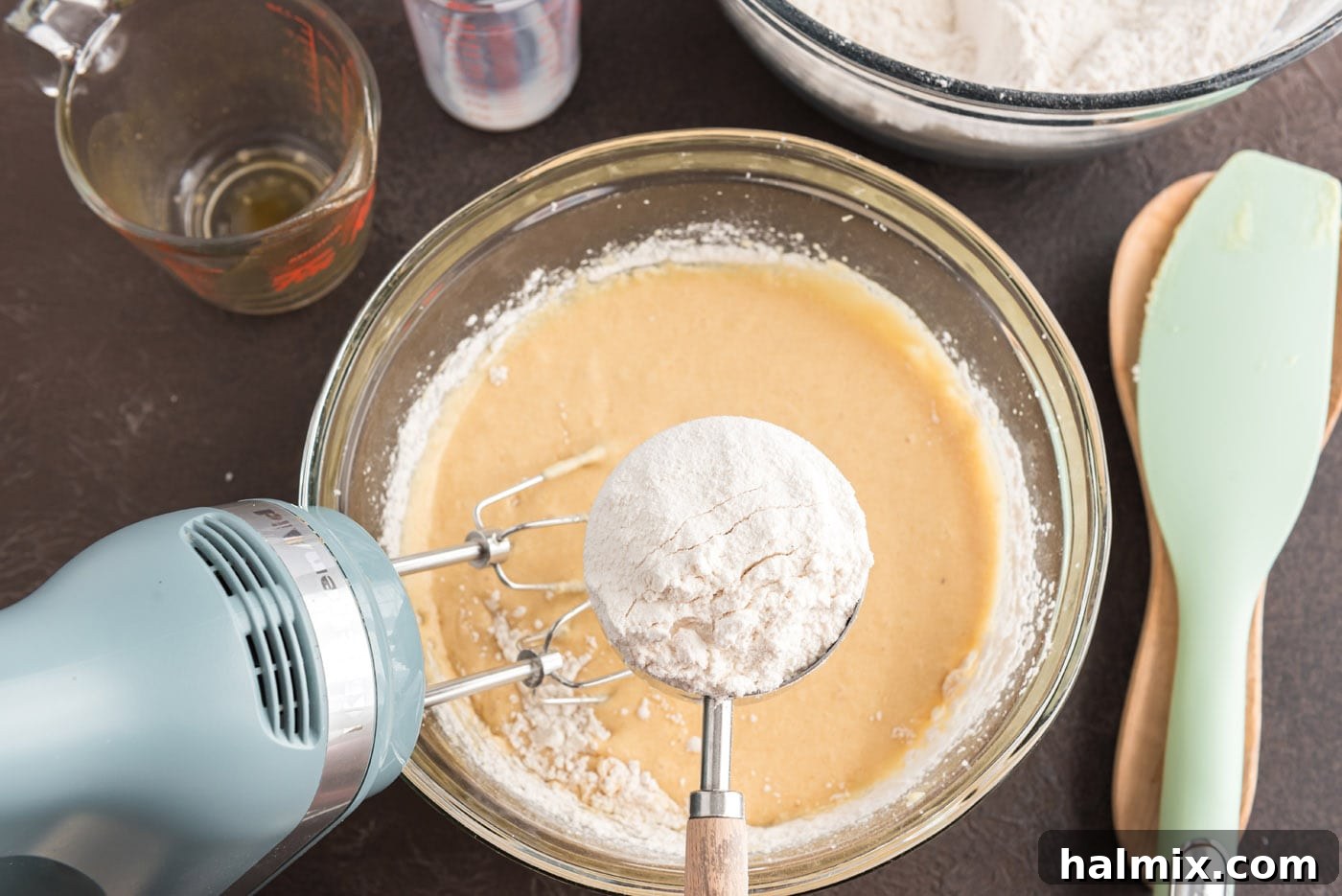 Adding flour mixture to wet ingredients in a bowl for apple cider doughnuts