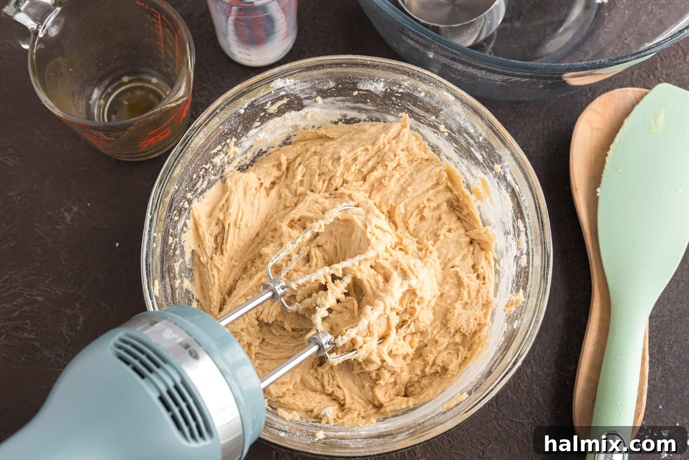 Mixing apple cider doughnuts batter with an electric mixer until just combined