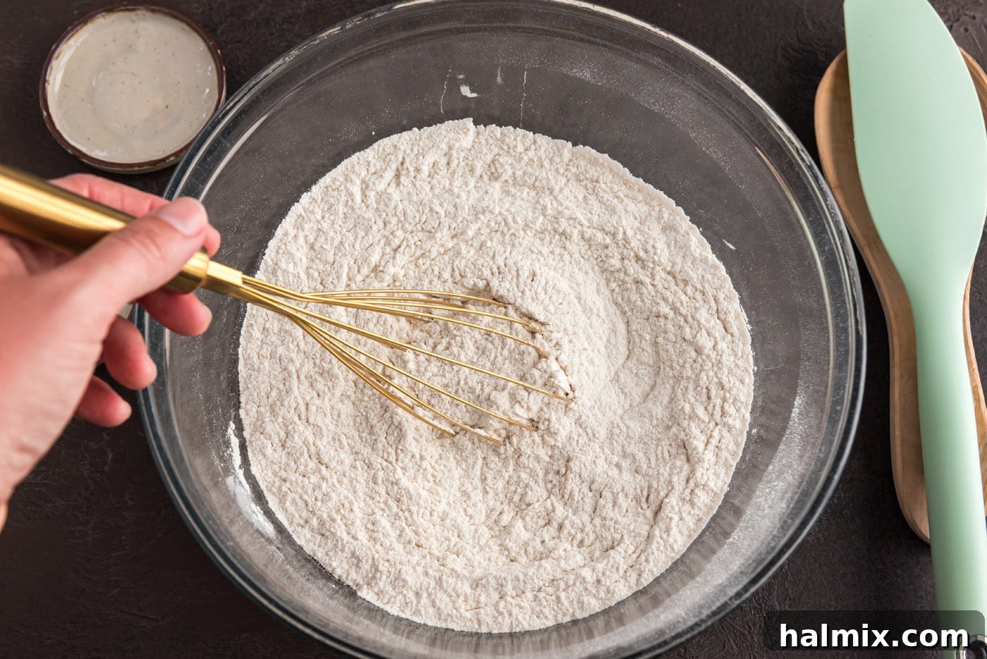 Whisking flour, cinnamon, and nutmeg in a bowl to ensure even distribution
