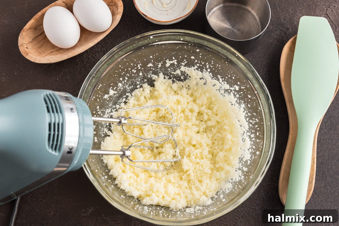 Electric mixer beating butter and sugar in a bowl until light and fluffy