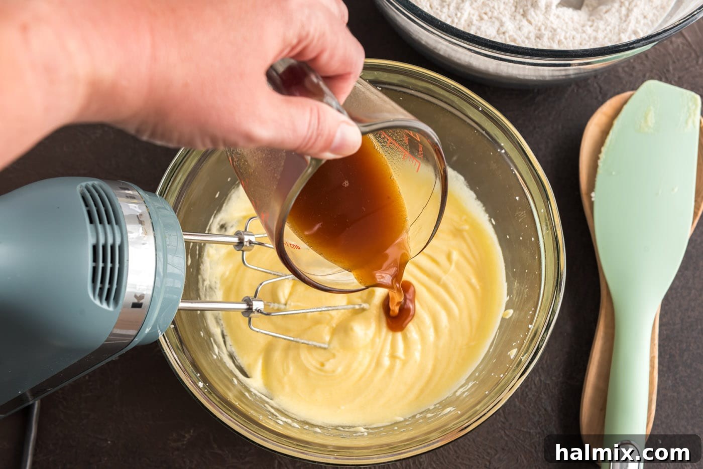 Pouring reduced apple cider into the doughnut batter