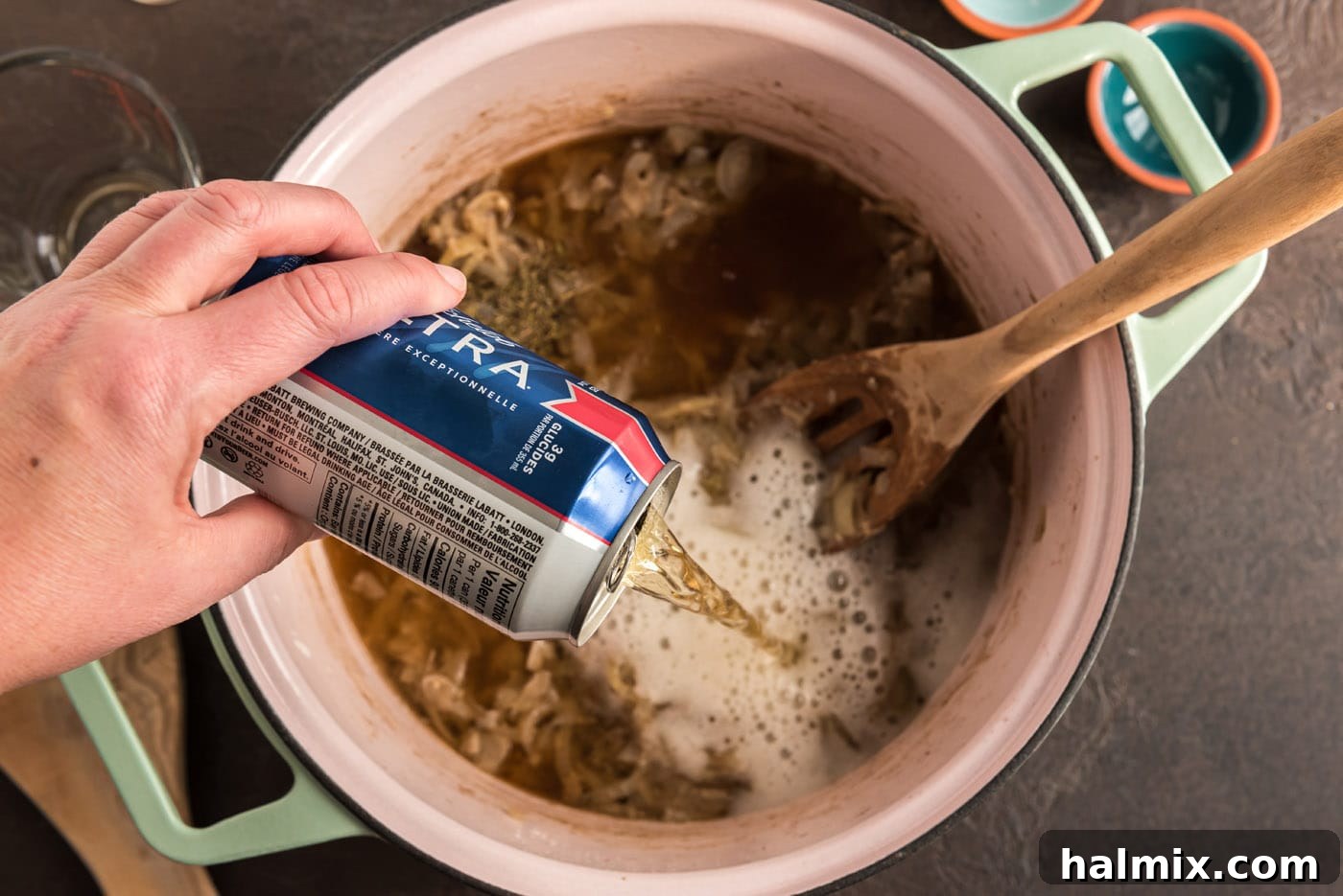 A stream of beer being poured into the Carbonnade, the key ingredient that gives this stew its distinctive Belgian character.