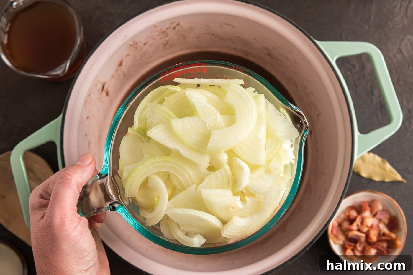 Thinly sliced onions added to a Dutch oven, beginning to soften and release their sweetness into the pan drippings.
