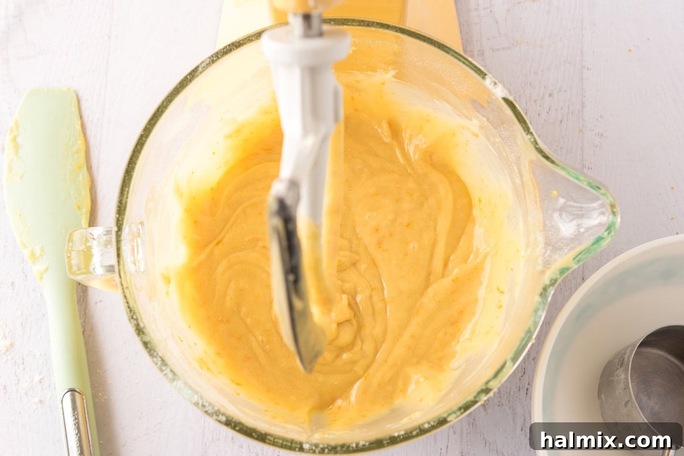 Orange cupcake batter in a stand mixer bowl, perfectly mixed.
