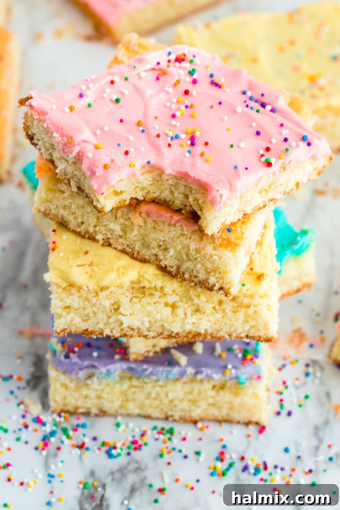 Frosted Sugar Cookie Bars: The Easiest Way to Indulge 2 Stack of Frosted Sugar Cookie Bars with a bite taken out of the top one