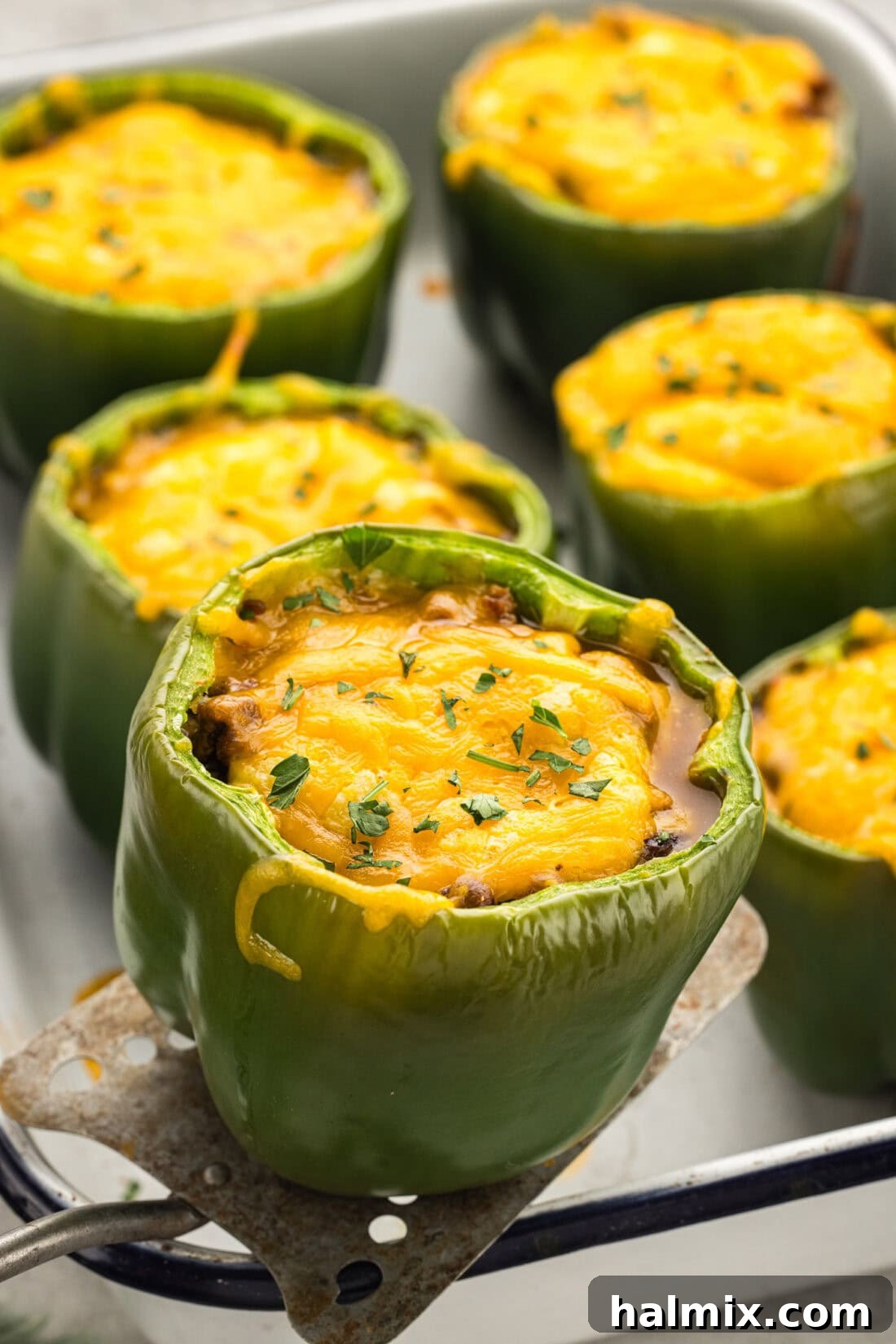 Southwest Chili Cornbread Stuffed Peppers 13 A baked Chili and Cornbread Stuffed Pepper being carefully lifted out of the pan with a spatula