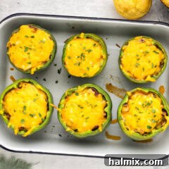 Overhead photo of Chili and Cornbread Stuffed Peppers in a pan, golden and bubbling
