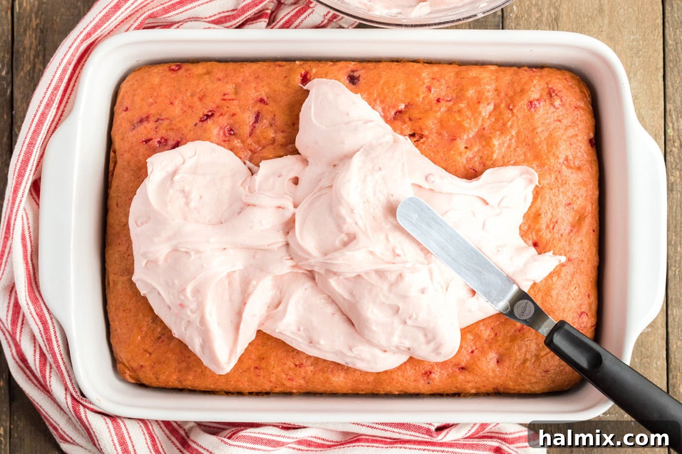 spreading frosting on to cherry cake
