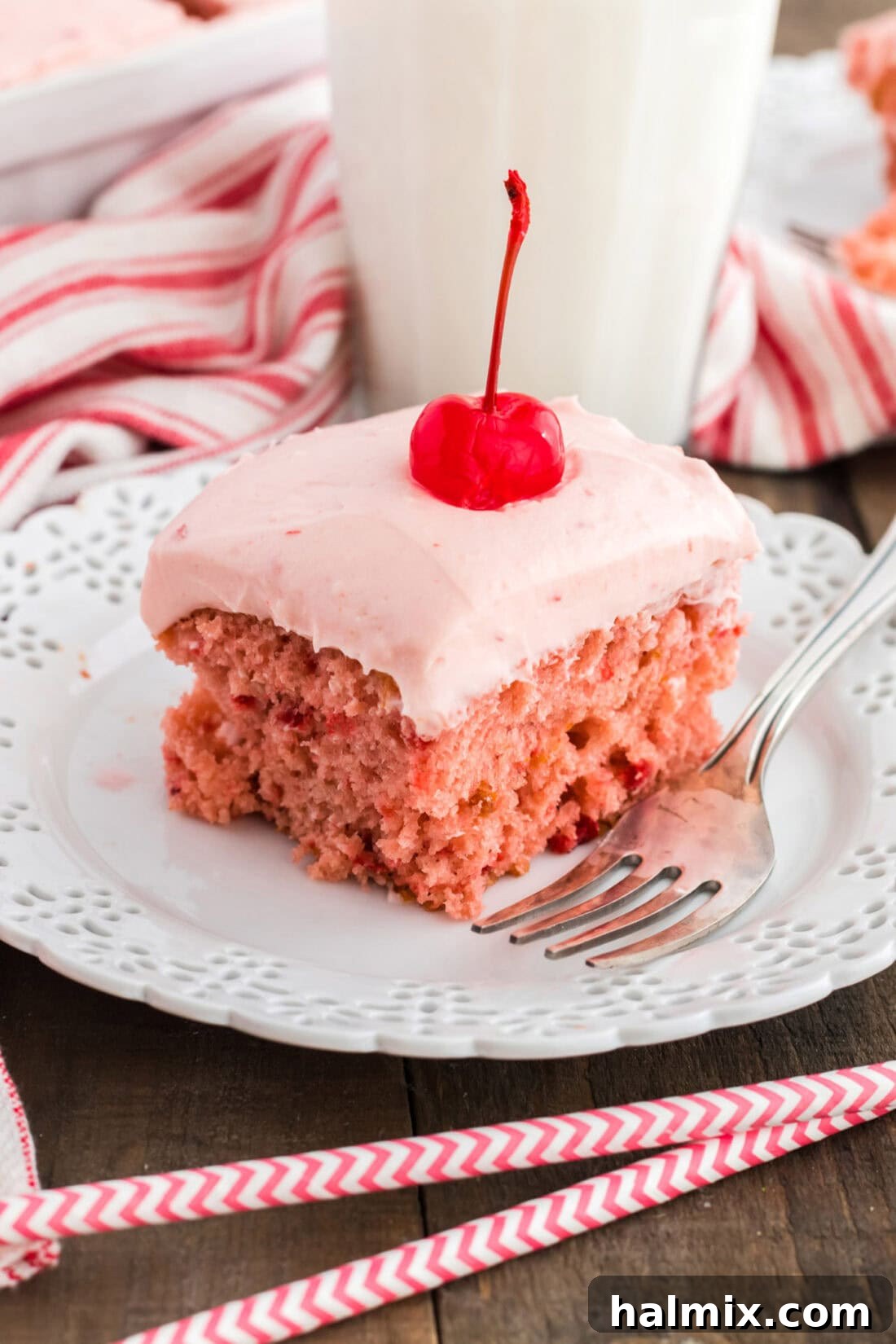 slice of cherry cake on a plate with straws in foreground