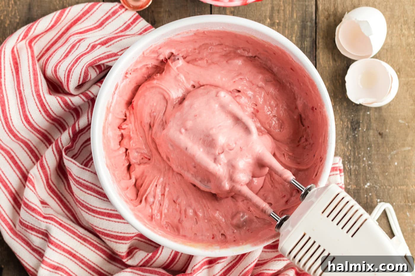 cherry cake mix batter in a bowl with mixer beaters