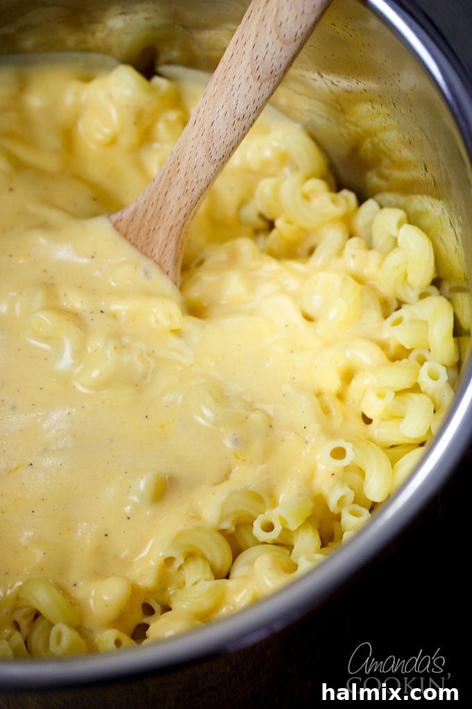 stirring cheese sauce into macaroni