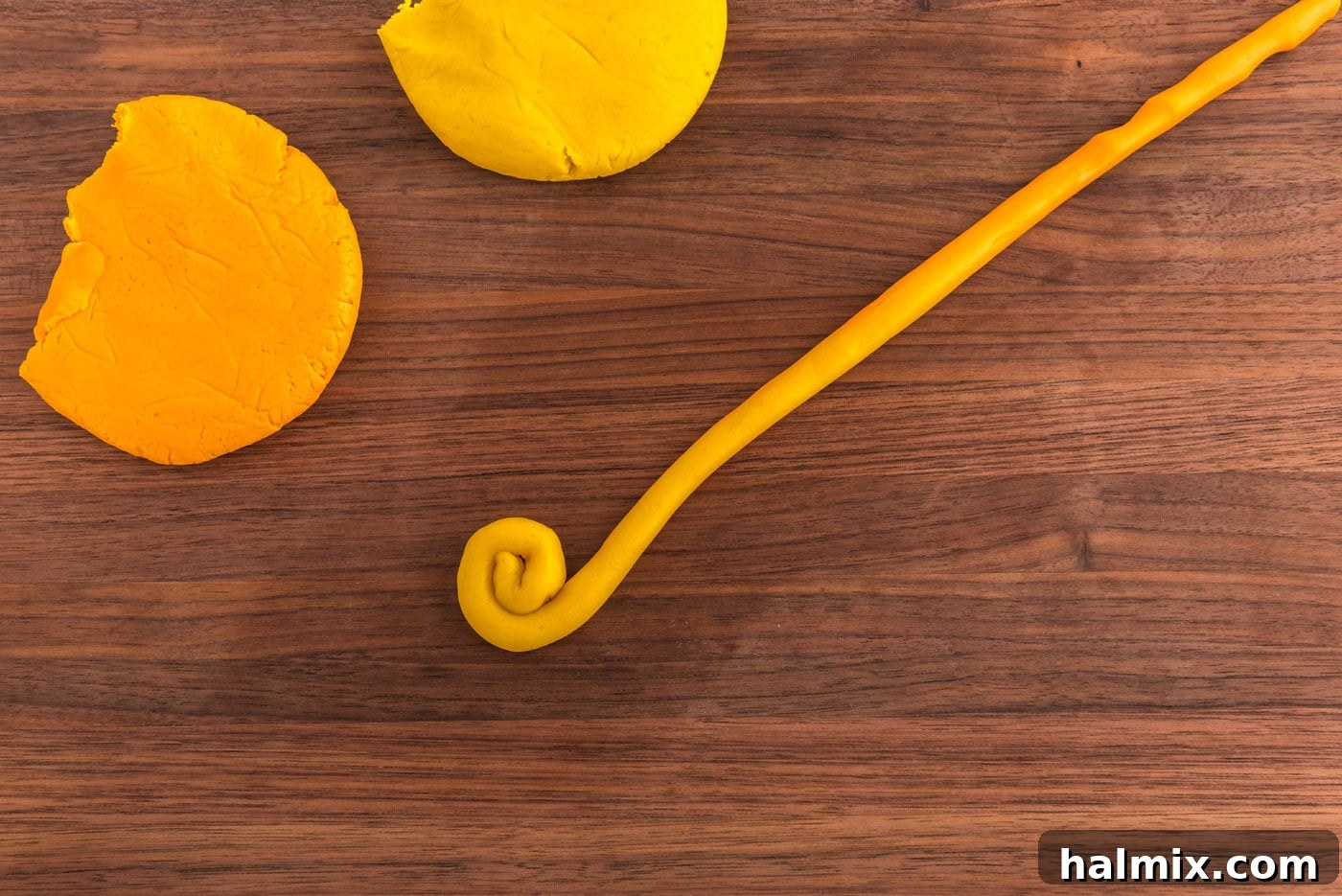 rolling yellow cookie dough into a coil