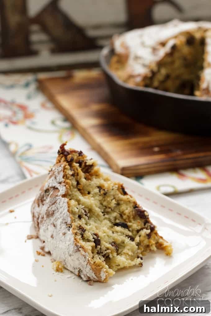 A perfectly sliced piece of Irish Soda Bread, revealing its moist, raisin-studded interior, resting on a white plate ready to be enjoyed.