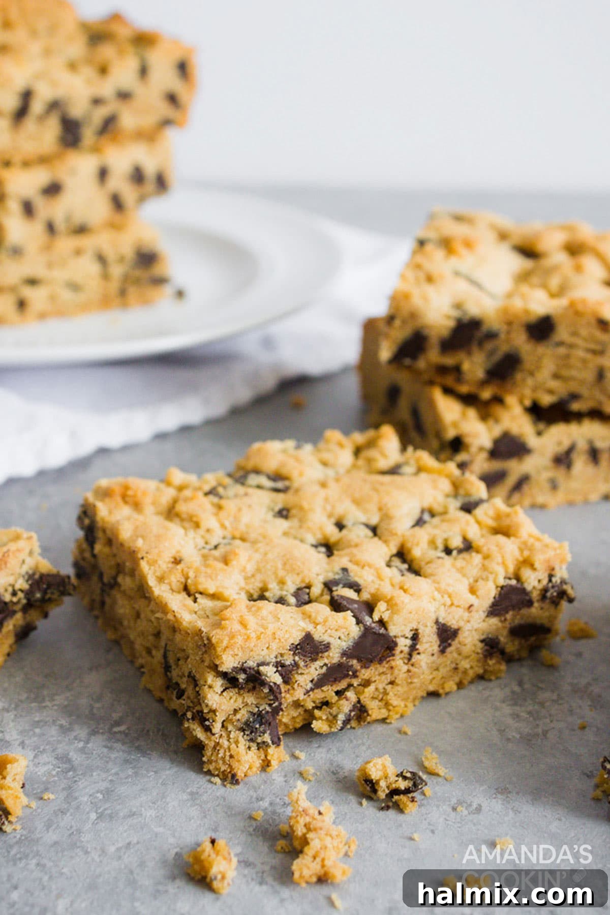 a chocolate chip cookie bar sitting on counter with more in background