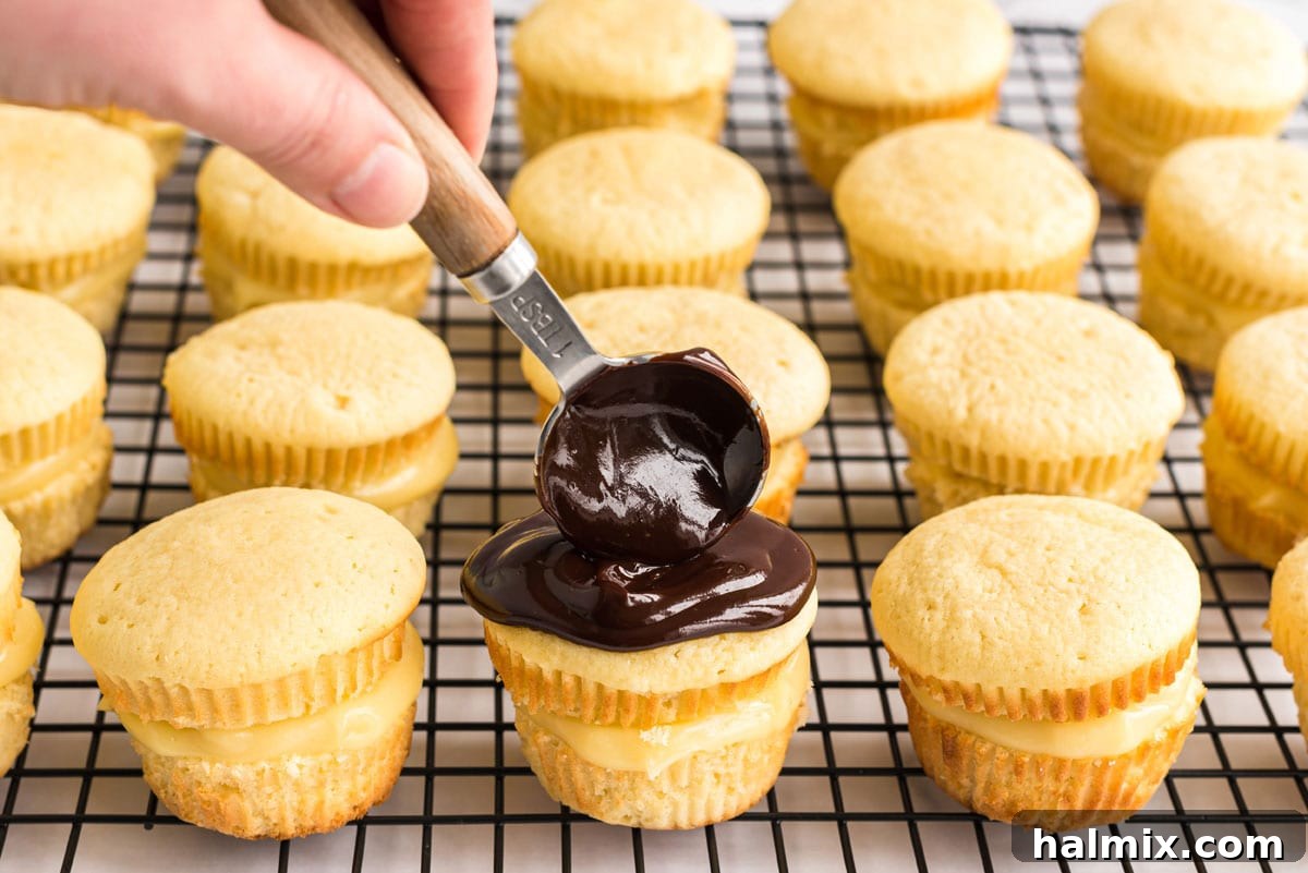 spreading ganache on top of cupcake with back of a spoon