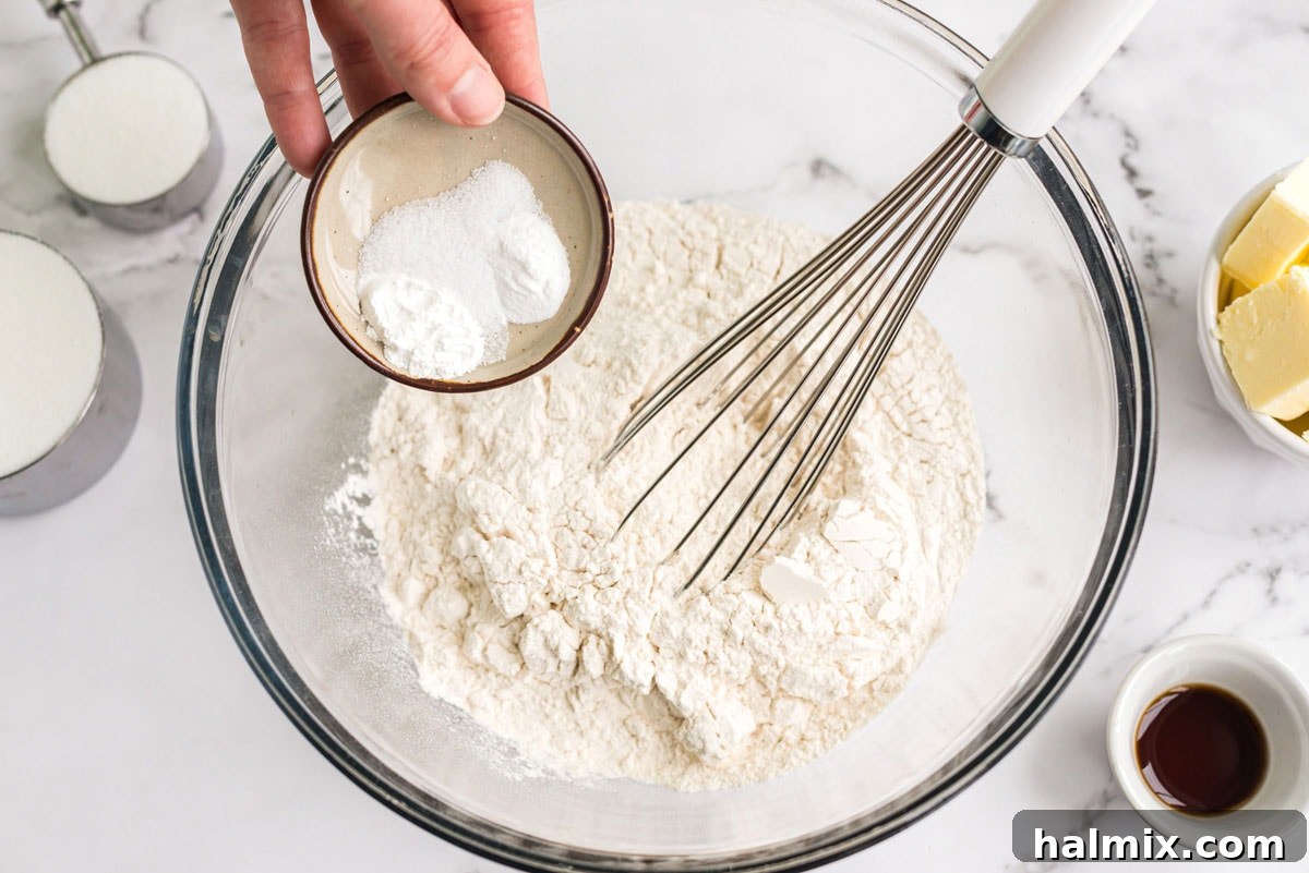 whisking flour and baking powder in a bowl with a whisk