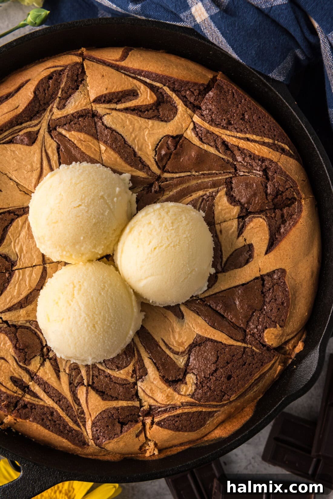 Close-up photo of a Peanut Butter Marbled Brownie Skillet Pie topped with three generous scoops of vanilla ice cream, ready to be enjoyed