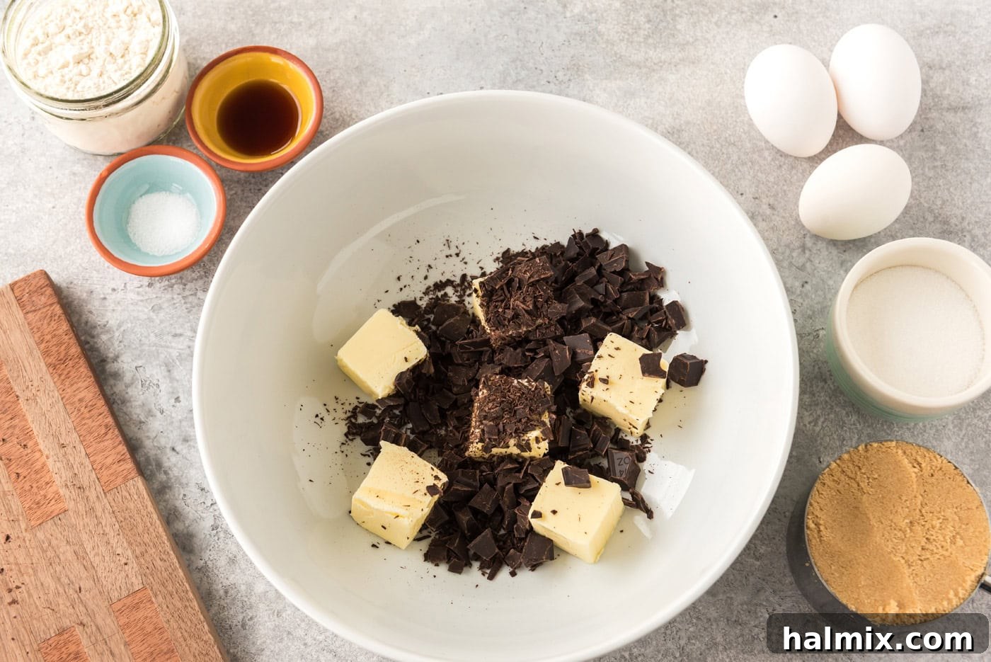 Sliced butter pats with chopped unsweetened chocolate in a bowl, ready for melting, step 3