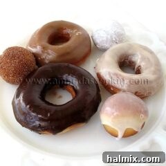A photo of a plate of an assortment of homemade doughnuts.