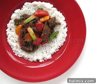 Sizzling Beef Stir-Fry with Sweet Peppers and Tomatoes 3 Close-up of a serving of Beef Stir Fry with Tomatoes and Peppers over fluffy white rice