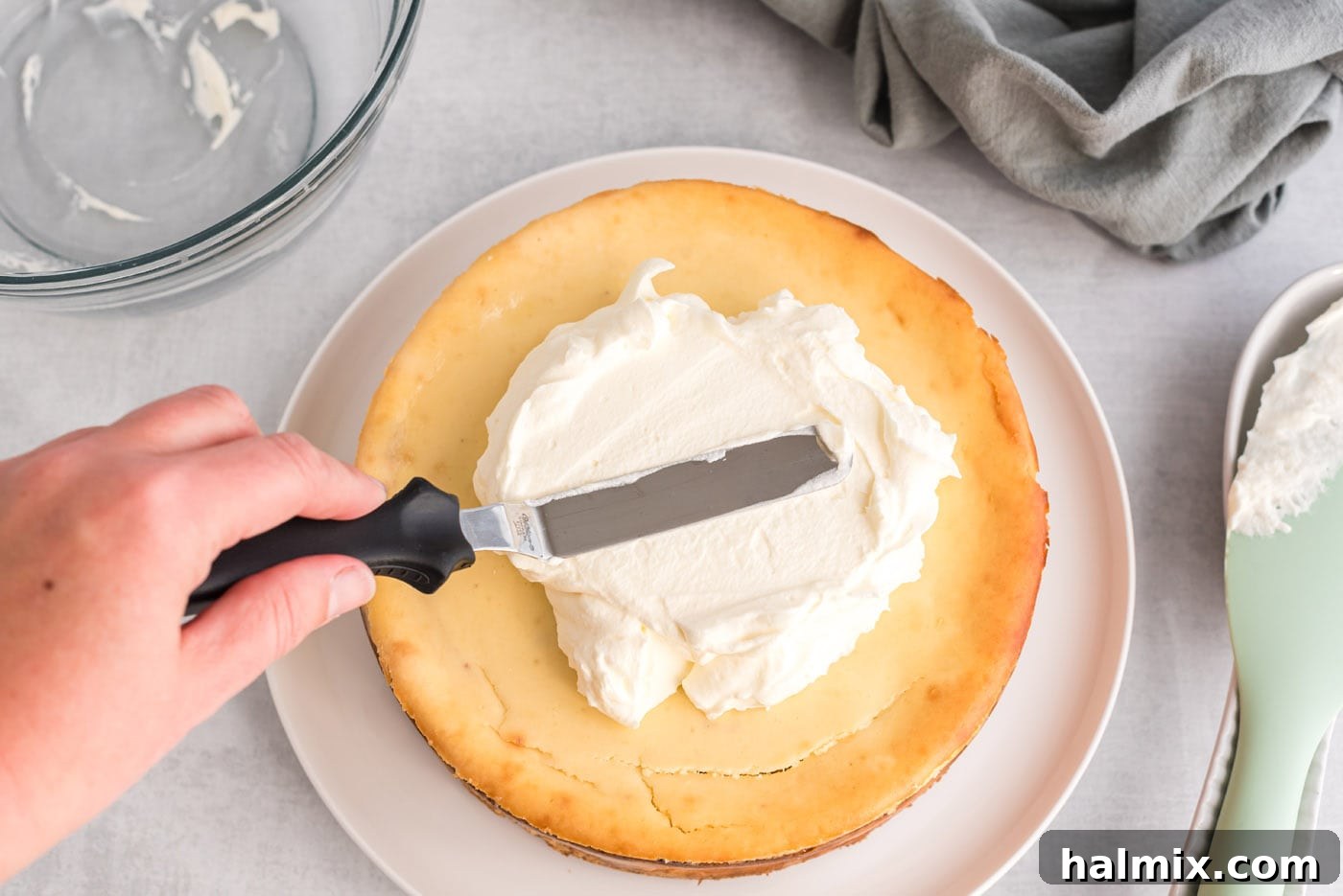 Regal Trifle Cheesecake 13 Icing spatula spreading whipped cream smoothly over the top of the cheesecake