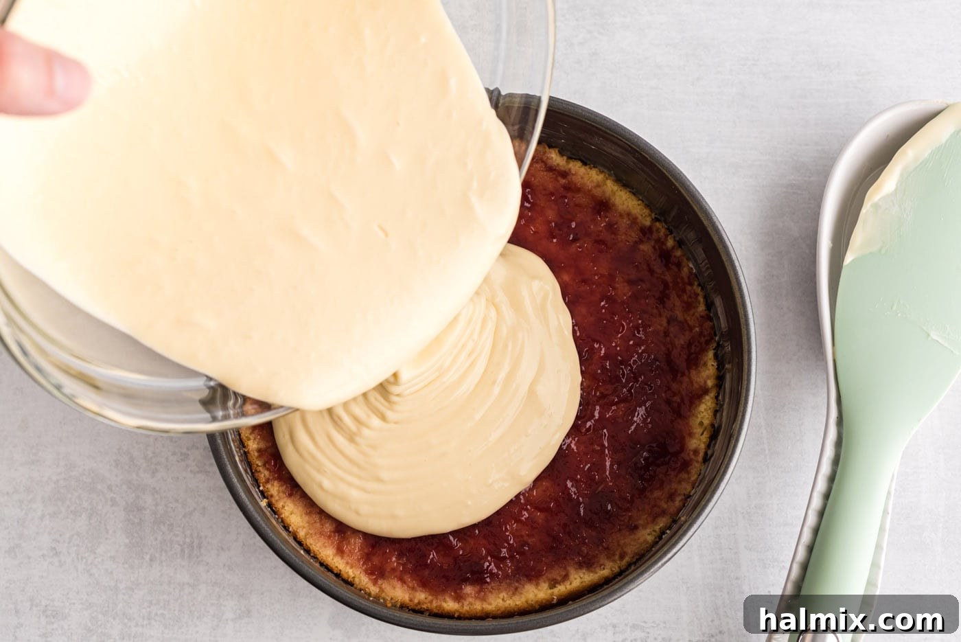 Regal Trifle Cheesecake 9 Pouring half of the cheesecake batter over the raspberry preserves and cake