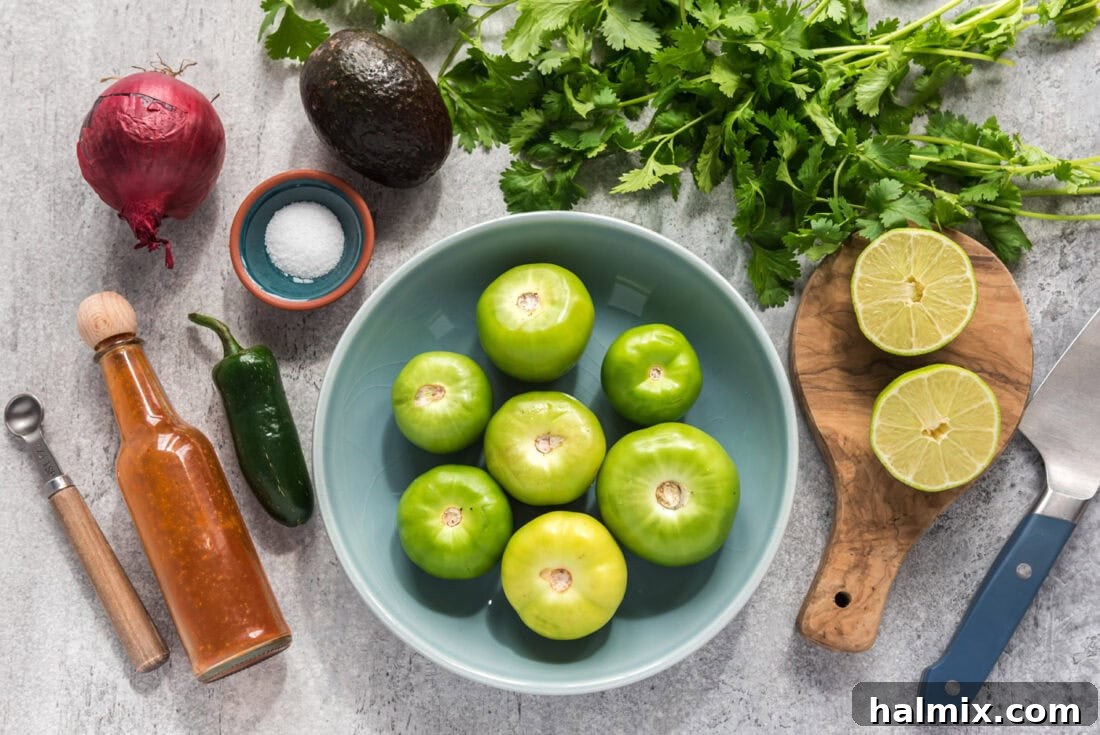 Fresh ingredients laid out for Tomatillo Onion Avocado Salsa including tomatillos, onions, avocado, lime, and cilantro