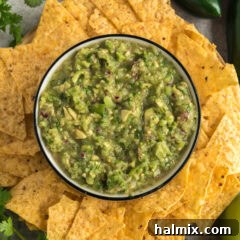 Bowl of Tomatillo Onion Avocado Salsa surrounded by tortilla chips, ready to be enjoyed