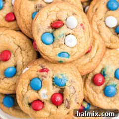 Close-up of freshly baked M&M cookies with red, white, and blue candies.