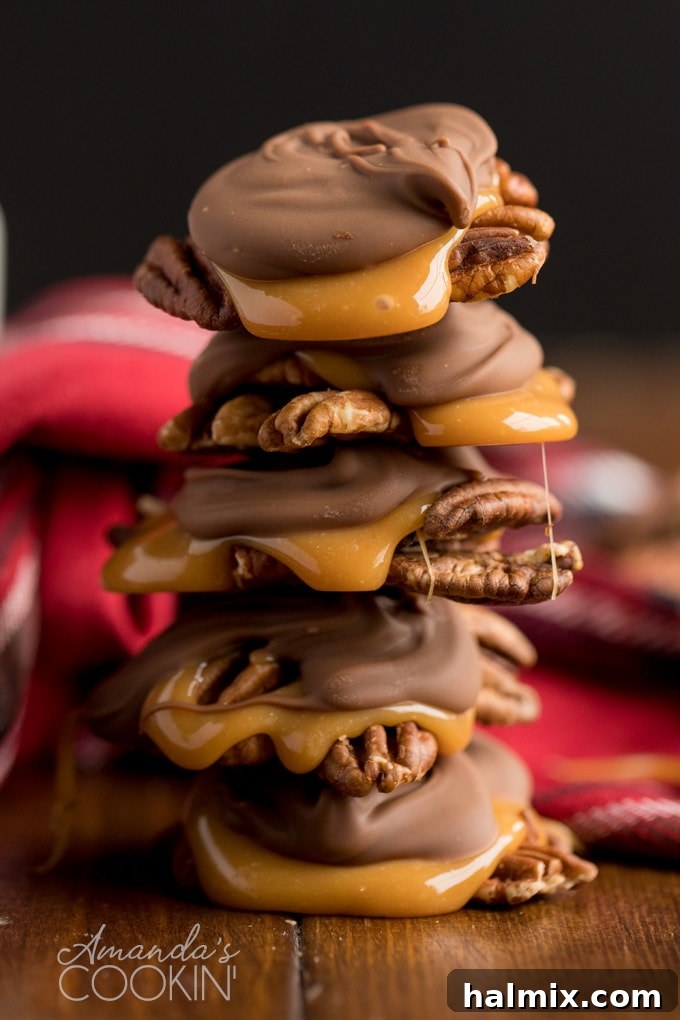 Stacked homemade chocolate turtles on a white surface, showcasing their delicious layers of pecan, caramel, and chocolate.
