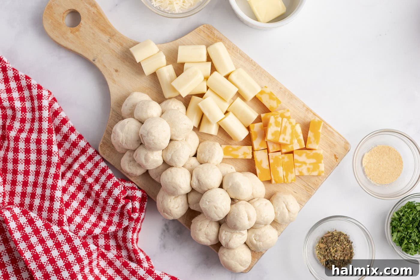 Festive Christmas Tree Pull-Apart Bread 5 Cut up cheese sticks and biscuits rolled into balls on a wooden board