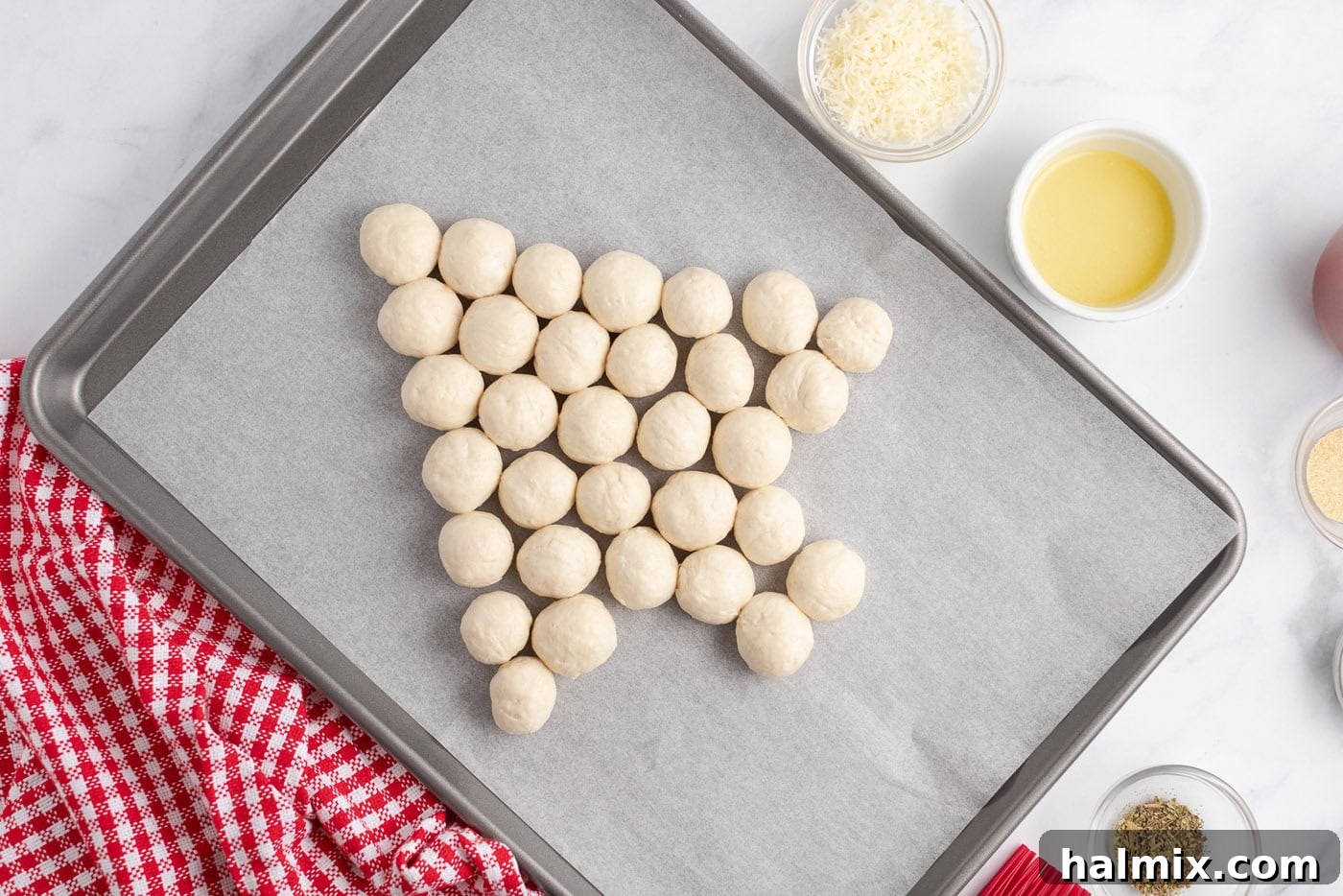 Festive Christmas Tree Pull-Apart Bread 7 Biscuit balls on a parchment lined baking sheet int he shape of a tree