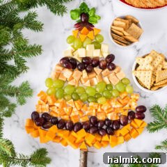 Christmas Tree Cheese Platter surrounded by crackers and Christmas tree branches