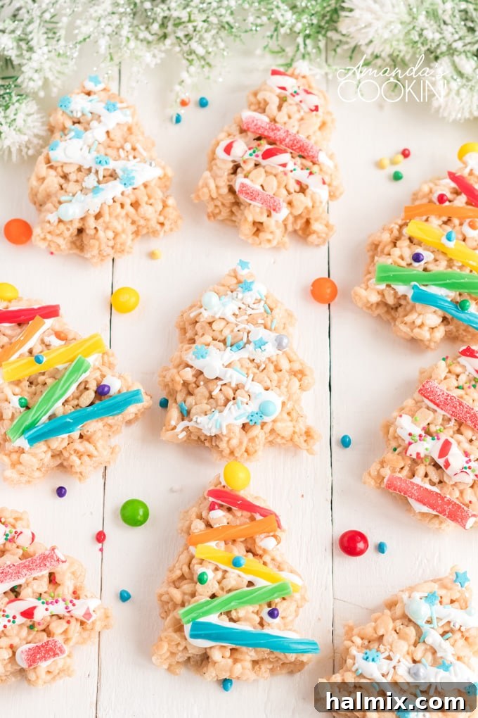 Make festive Christmas Tree Rice Krispie Treats with your family. Simple ingredients like Rice Krispies, marshmallows, and candy make these treats adorable and fun to decorate. rice krispie treats shaped like christmas trees with colorful decorations