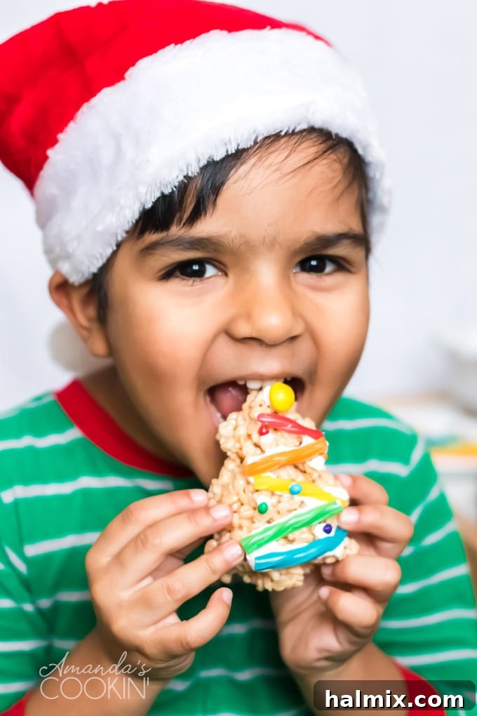 A child enjoying a homemade Christmas Tree Rice Krispie Treat, highlighting the kid-friendly appeal of this recipe. little boy happily eating a Christmas Tree Rice Krispie Treat