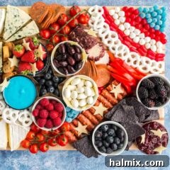 A festive patriotic charcuterie board, artistically arranged with red, white, and blue foods, serving as the main image for the recipe card.