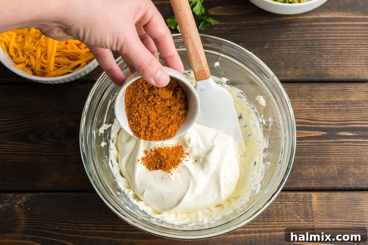 adding taco seasoning to sour cream and cream cheese