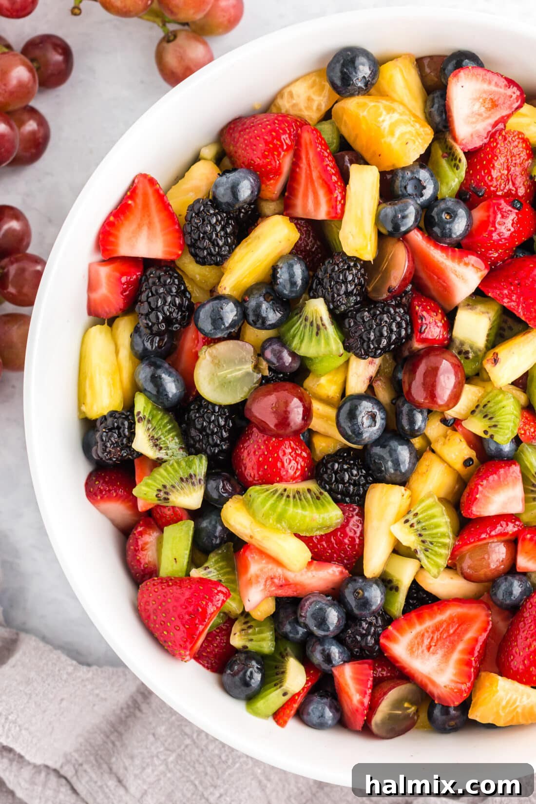 My cousin insists on having fruit salad at every holiday. This is our family's go-to recipe and it's always a favorite. Close-up photo of a bowl brimming with colorful fruit salad, highlighting the fresh textures and vibrant hues