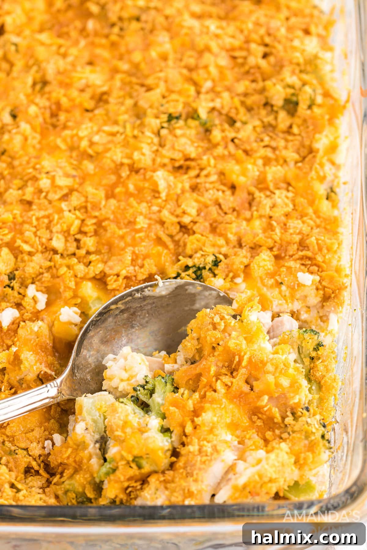 A serving of Chicken Broccoli Rice Casserole being scooped with a spoon