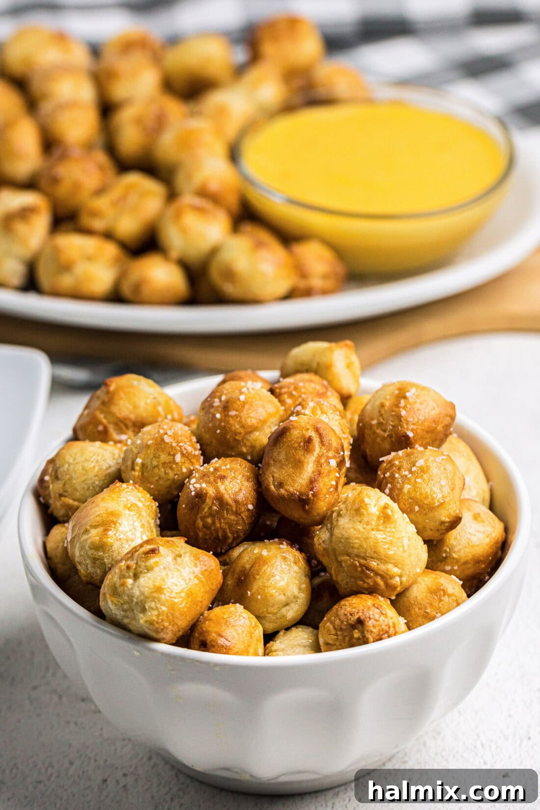 Golden Air Fried Pretzel Poppers 2 Bowl of Air Fryer Pretzel Bites with more pretzel bites on a platter in the background