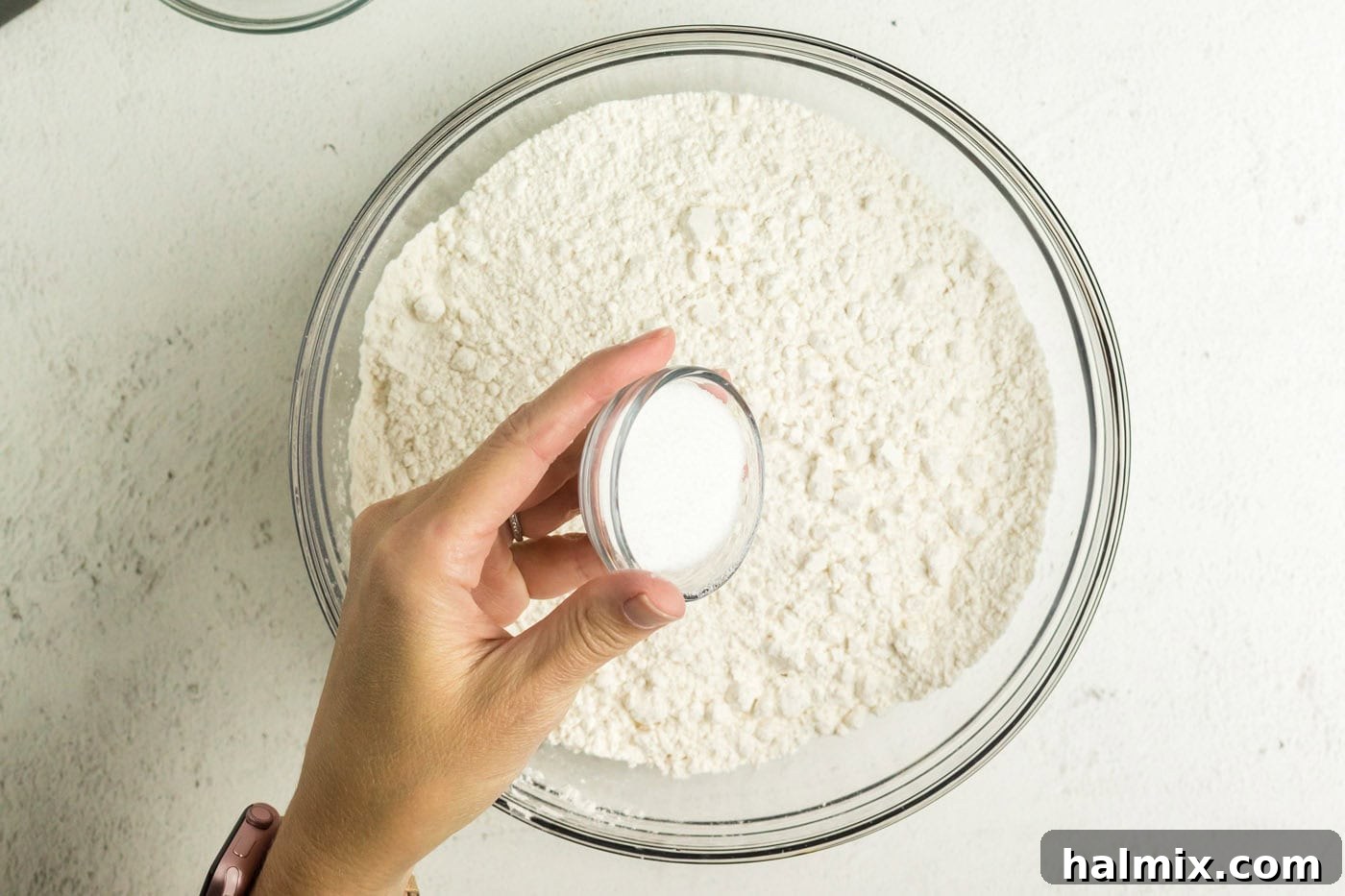 Golden Air Fried Pretzel Poppers 5 Sugar being added into a bowl of flour